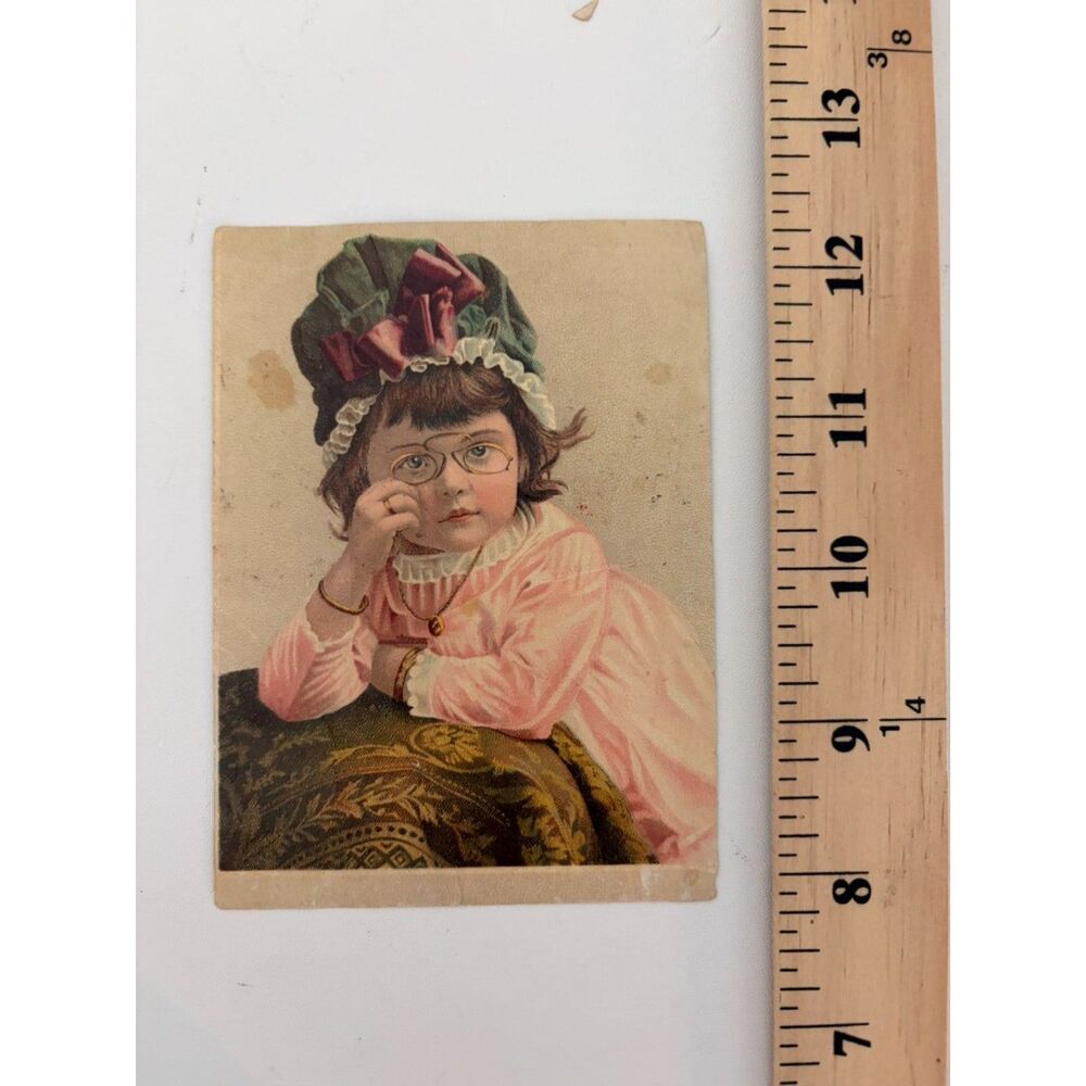 victorian chromolithograph trade card of girl in glasses and bonnet